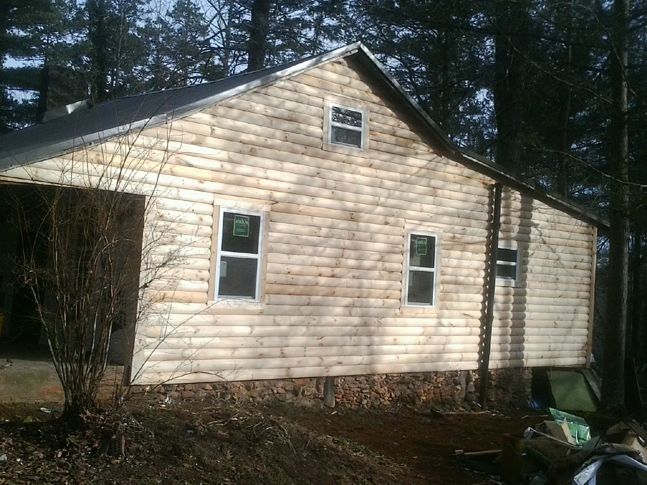 New log siding and dark metal roofing on a gable end in Bennington