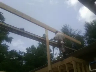Carpenter setting a ridge beam over a new addition frame — Ice Dam Removal by Roofing Brothers in Bennington